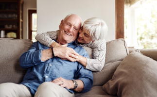 Médica, vestindo jaleco branco com um estetoscópio no pescoço, atendendo paciente que está sentada em uma maca.